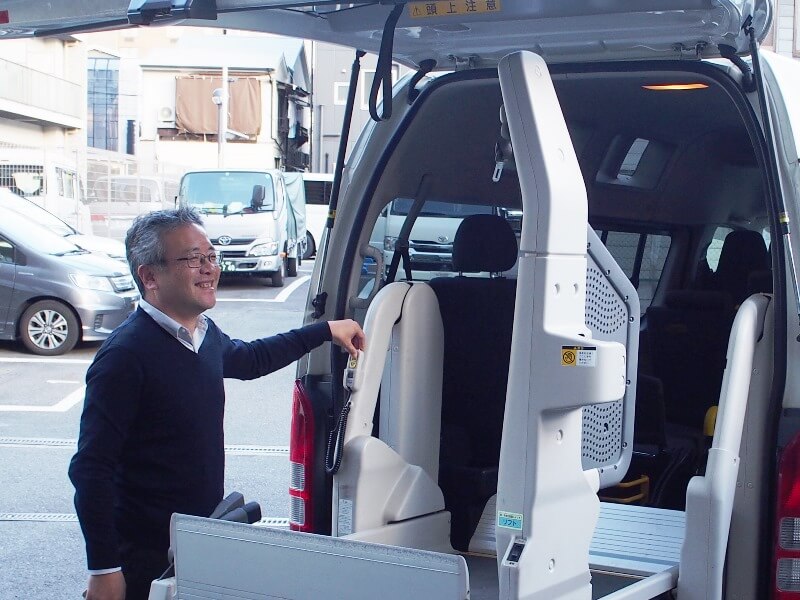 笑顔で電動リフトを操作する吉田さん