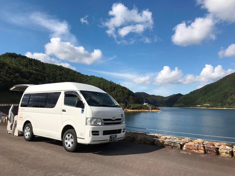 猪苗代湖をバックに介護タクシー車両外観