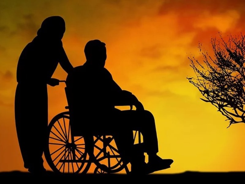 車いすに乗った人と介助者のシルエット