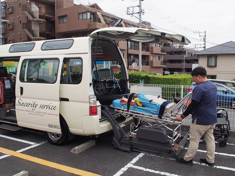 ストレッチャーを車両に格納する飯田さん