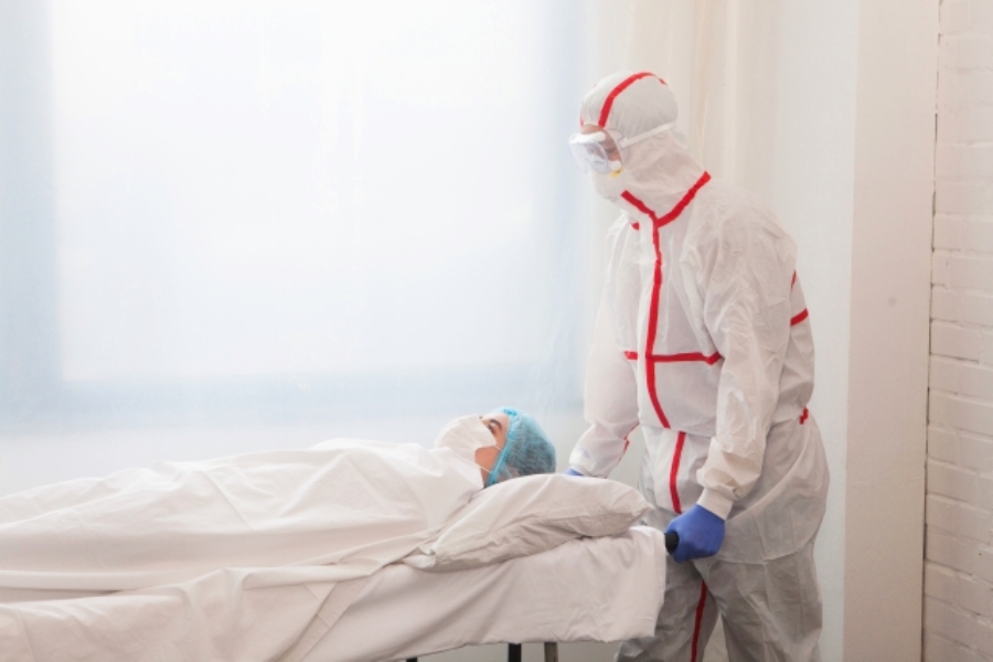 防護服姿で患者搬送をする医療従事者