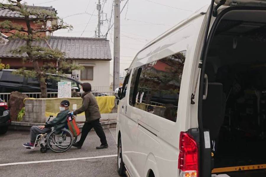自宅まで車いすを押す松本さん